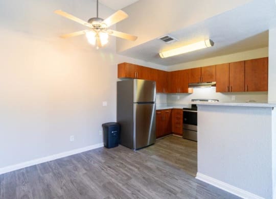 a kitchen with a refrigerator and a ceiling fan