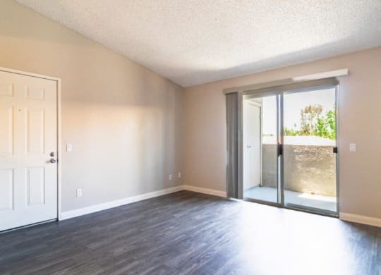 an empty living room with a door to a patio