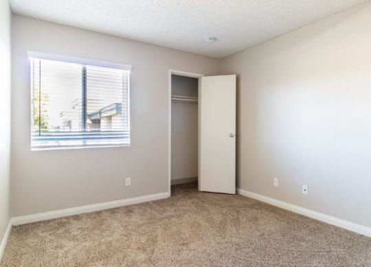 an empty room with a window and a closet