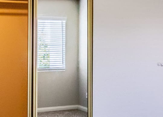 a mirror with a reflection of a window and a door