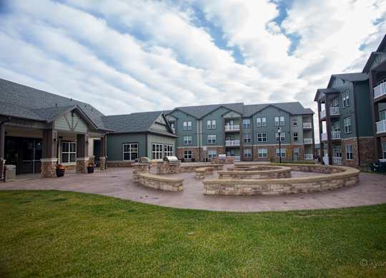 A courtyard surrounded by buildings with a stone fountain in the middle.