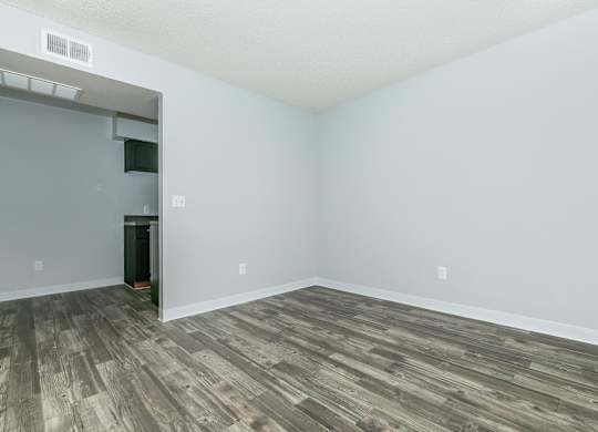 A room with a wooden floor and a white wall.