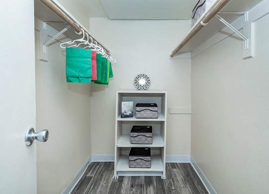A small, clean, and organized closet with a shelf and a door.