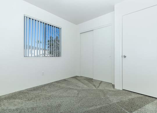 A room with a window and two doors.