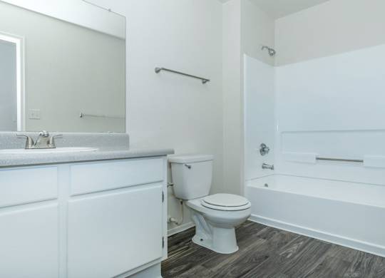 A white bathroom with a toilet, sink, and bathtub.