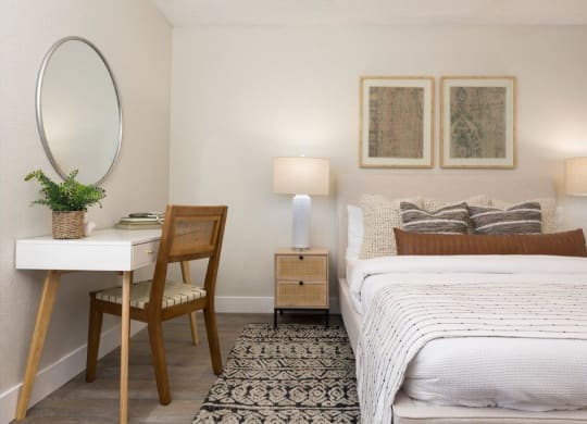 a bedroom with a bed and a desk with a mirror