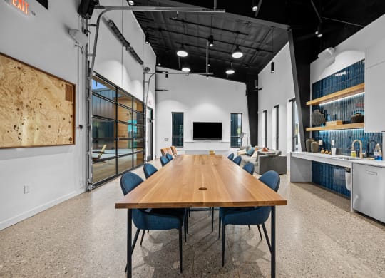 a large conference room with a long wooden table and blue chairs