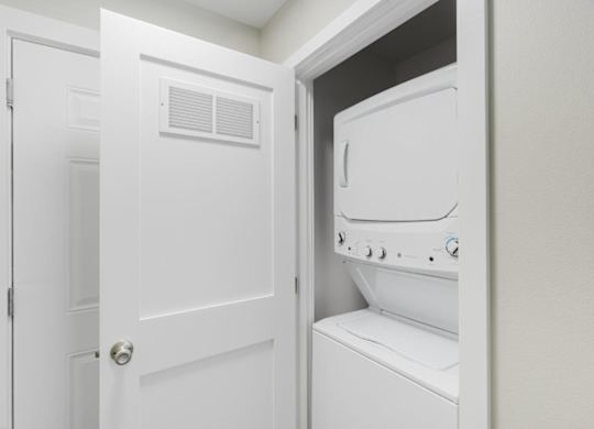 A white door is open to a white dryer.
