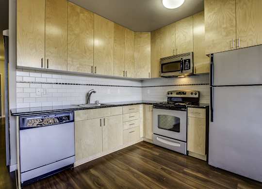 A kitchen with wooden cabinets and a white refrigerator.