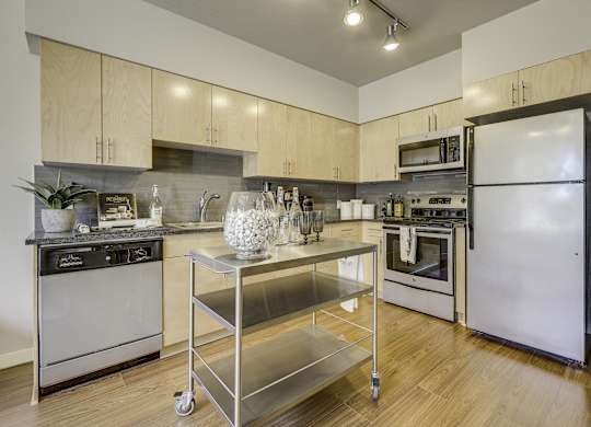 A modern kitchen with a stainless steel oven and a white fridge.