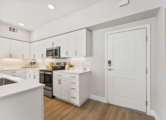 a white kitchen with white cabinets and a black stove and