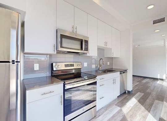 A modern kitchen with white appliances and cabinets.