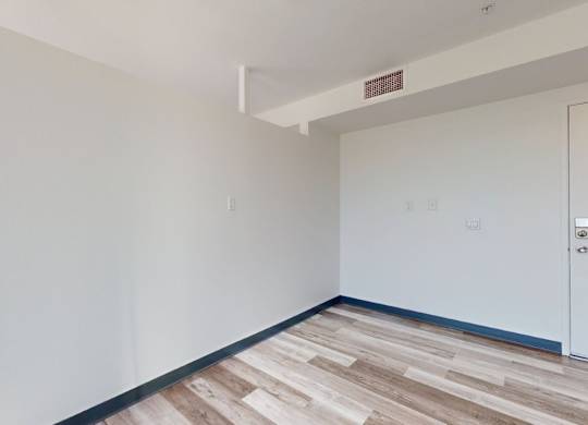 A room with a white wall and a door.
