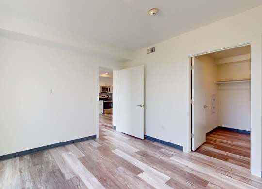 A room with a white wall and a wooden floor.