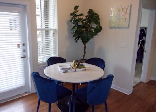 A dining room with a round table and blue chairs.