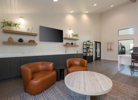 a living room with two leather chairs and a table