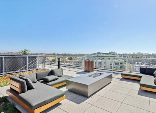 A rooftop patio with a fire pit and seating area.