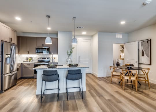 an open kitchen and dining area with a large island and stainless steel appliances