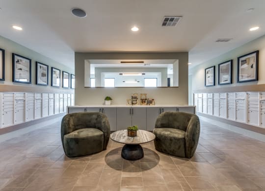 a lobby with two chairs and a counter with mailboxes
