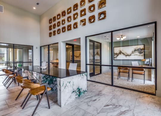 an open kitchen and dining room with a marble counter top and chairs