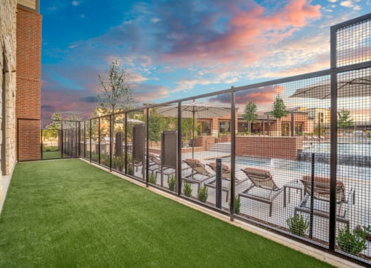 a yard with a fence and tables and chairs on it