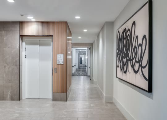 a hallway with a painting on the wall and a door