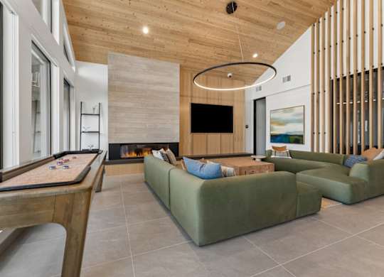 A modern living room with a pool table and a fireplace.
