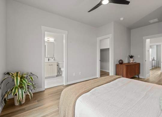 A bedroom with a large bed and a ceiling fan.