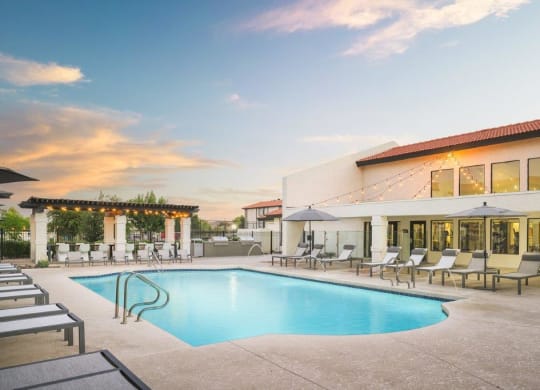 a swimming pool in front of a hotel with a building