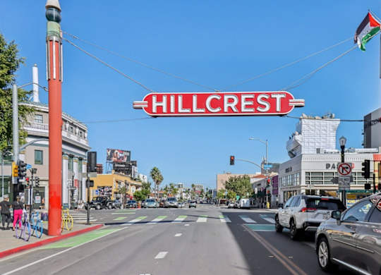 A street view of Hillcrest with cars and a bicycle.