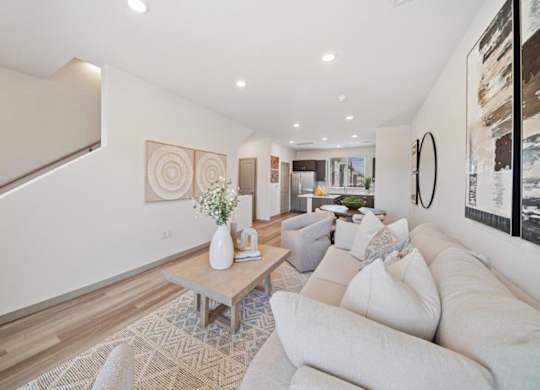 A living room with a white couch and a wooden coffee table.