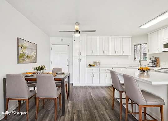 A kitchen with a dining table and chairs.