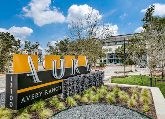 A large sign that says AURA in front of a building.