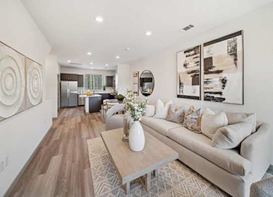 A living room with a couch, coffee table, and artwork on the walls.