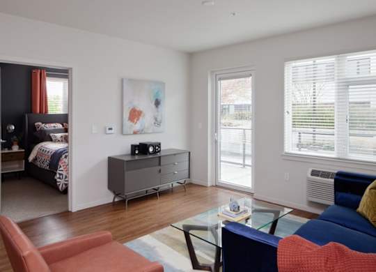 A living room with a blue couch and a red chair.