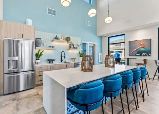 Marlette open kitchen with stainless steel appliances and blue chairs