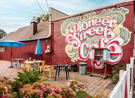 A mural on a red wall says Pioneer Street.