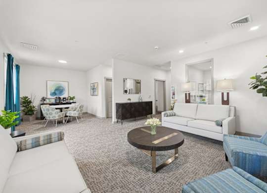 A living room with a white couch, a coffee table, and a fireplace.