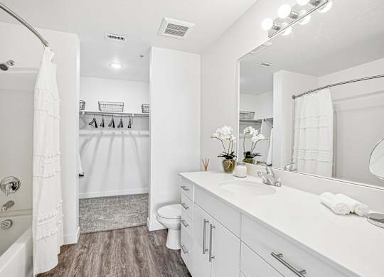 A white bathroom with a white tub, sink, and toilet.