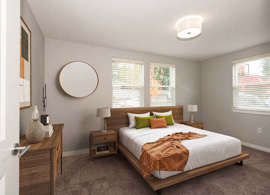 A bedroom with a bed, nightstands, and a round mirror on the wall.