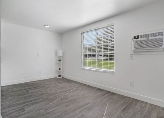 A room with a window and a wall-mounted air conditioner unit.