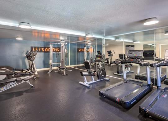 A gym with treadmills, exercise bikes, and other equipment.