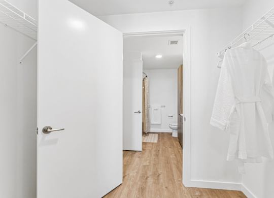 A white bathroom with a towel hanging on the rack.