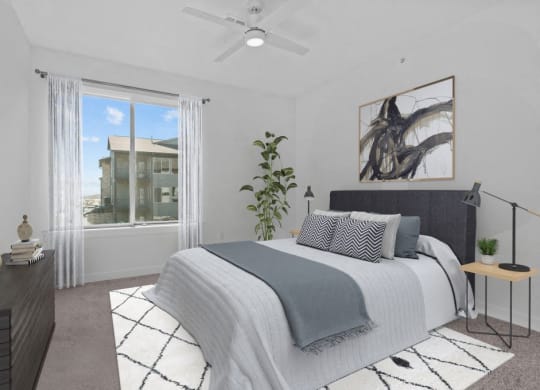 a bedroom with a large window and a bed