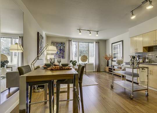A modern dining room with a wooden table and chairs.