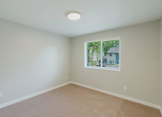 A room with a window and carpeted floor.