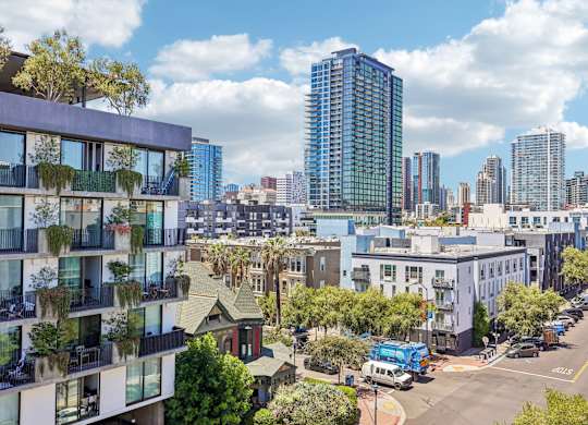 A city street with a blue truck and a tall building in the background.