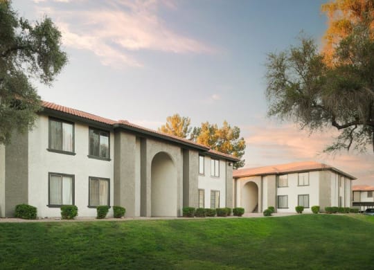 a building with a lawn and trees in front of it