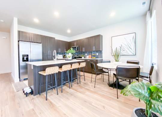 A kitchen with a bar area and a dining table.