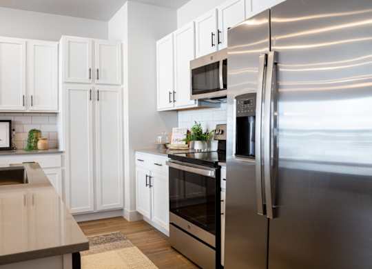 A modern kitchen with stainless steel appliances and white cabinets.